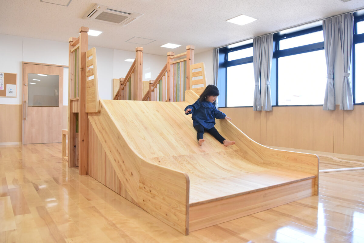 木製滑り台を上手に滑る少女