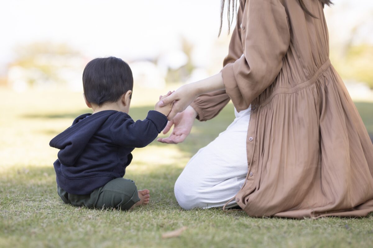 子どもの手をとるママ