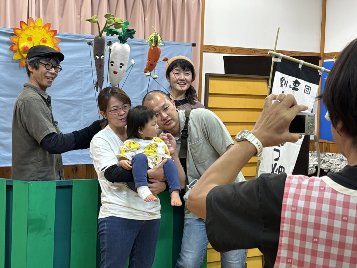 人形と写真を撮る親子