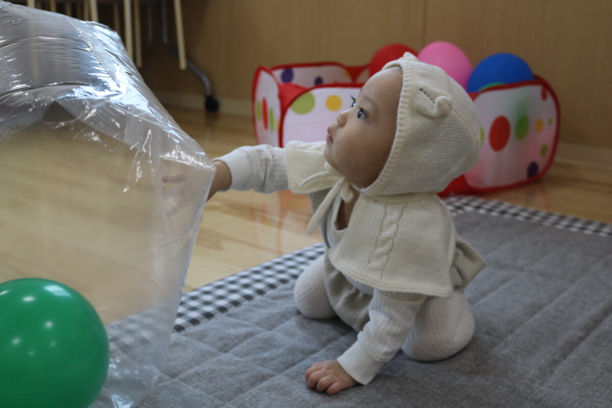 大きな袋で遊ぶ赤ちゃん